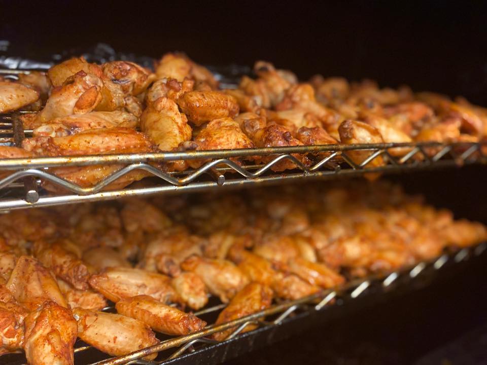 racks of wings in a smoker