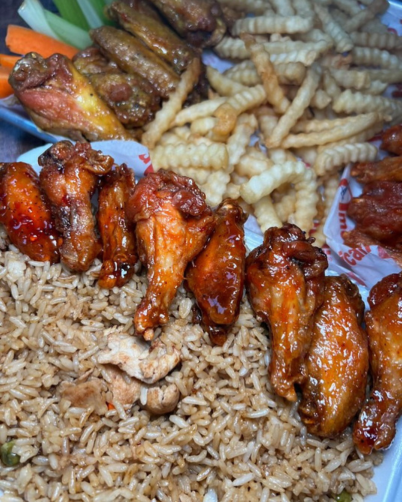 a table full of rice, wings, and fries