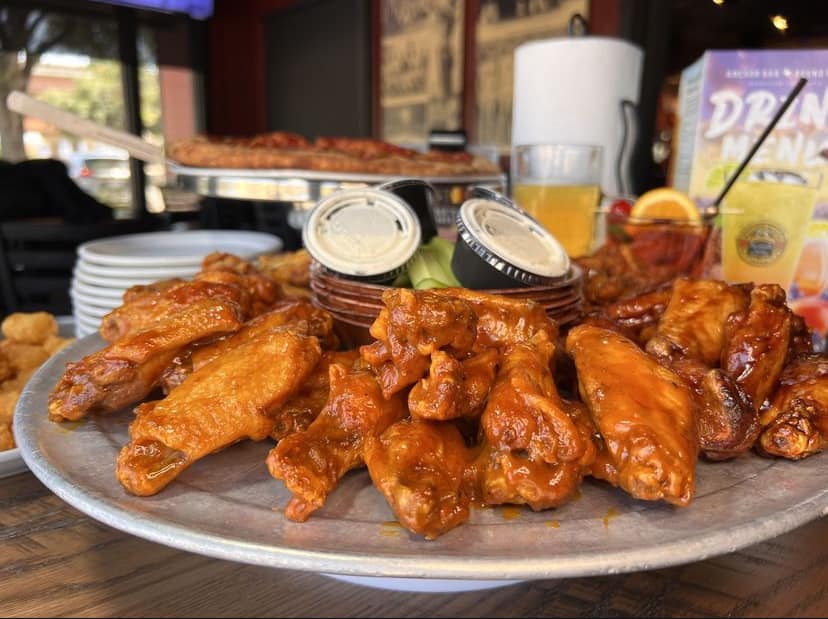 a round plate full of buffalo wings and celery