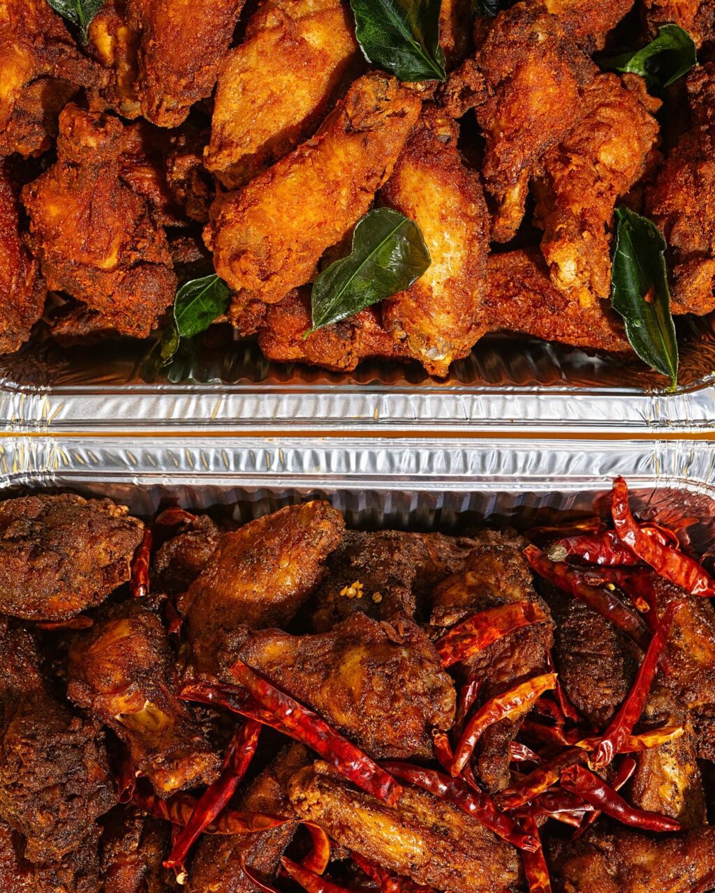 two chafing pans full of crispy hot wings